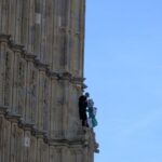 Un hombre se encarama a la torre del Big Ben enarbolando la bandera palestina